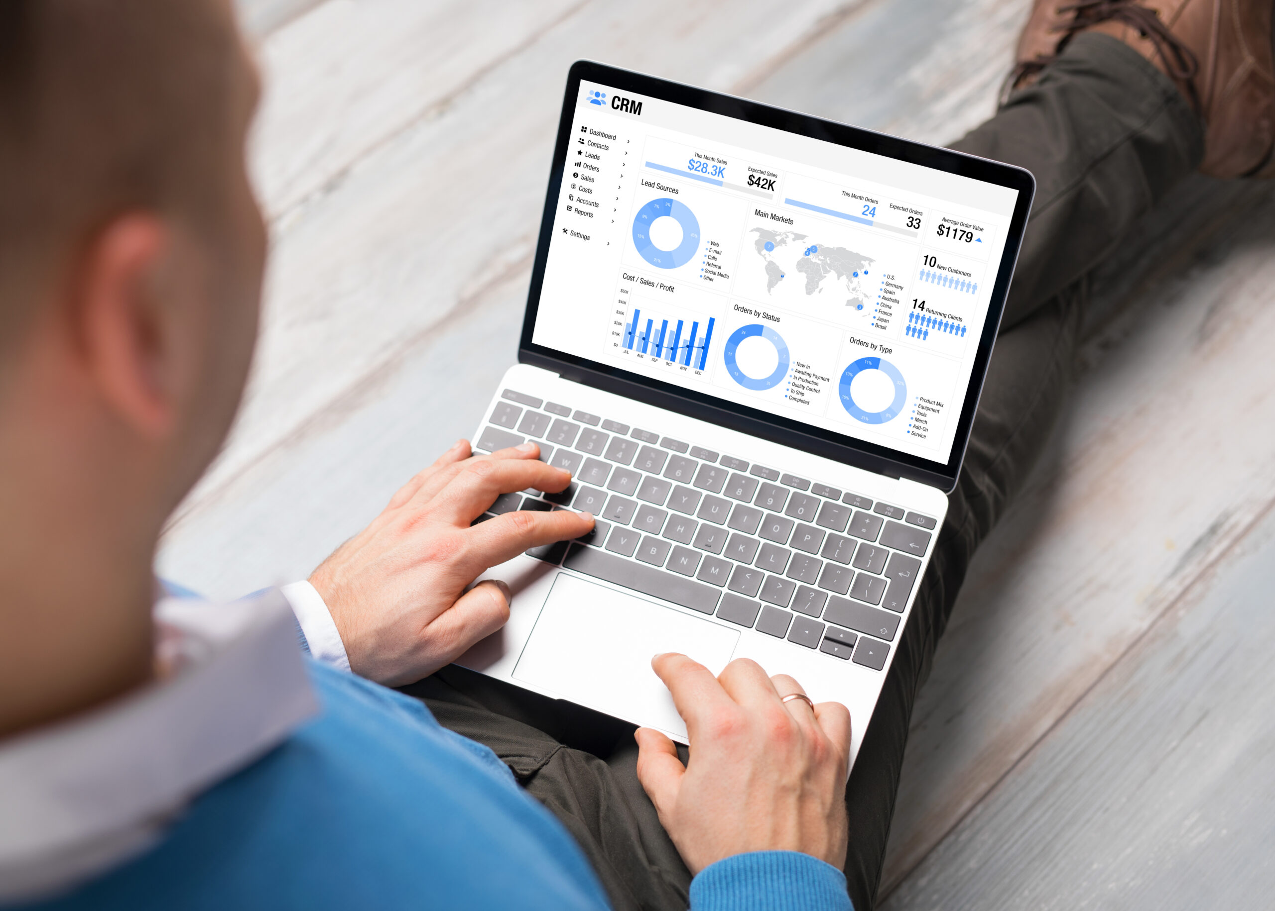 Man using CRM software on laptop with different graphs and chart